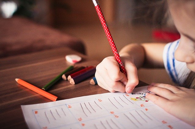 a close up of a child drawing on a piece of paper